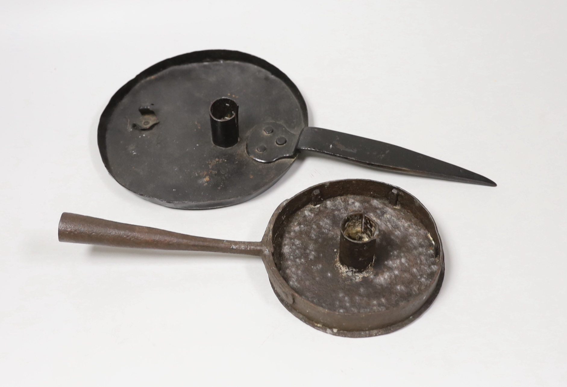 An 18th century iron chamber candlestick, with ‘spike’ handle and an 18th / 19th century iron chamber candlestick, with projecting handle, largest 33cm long